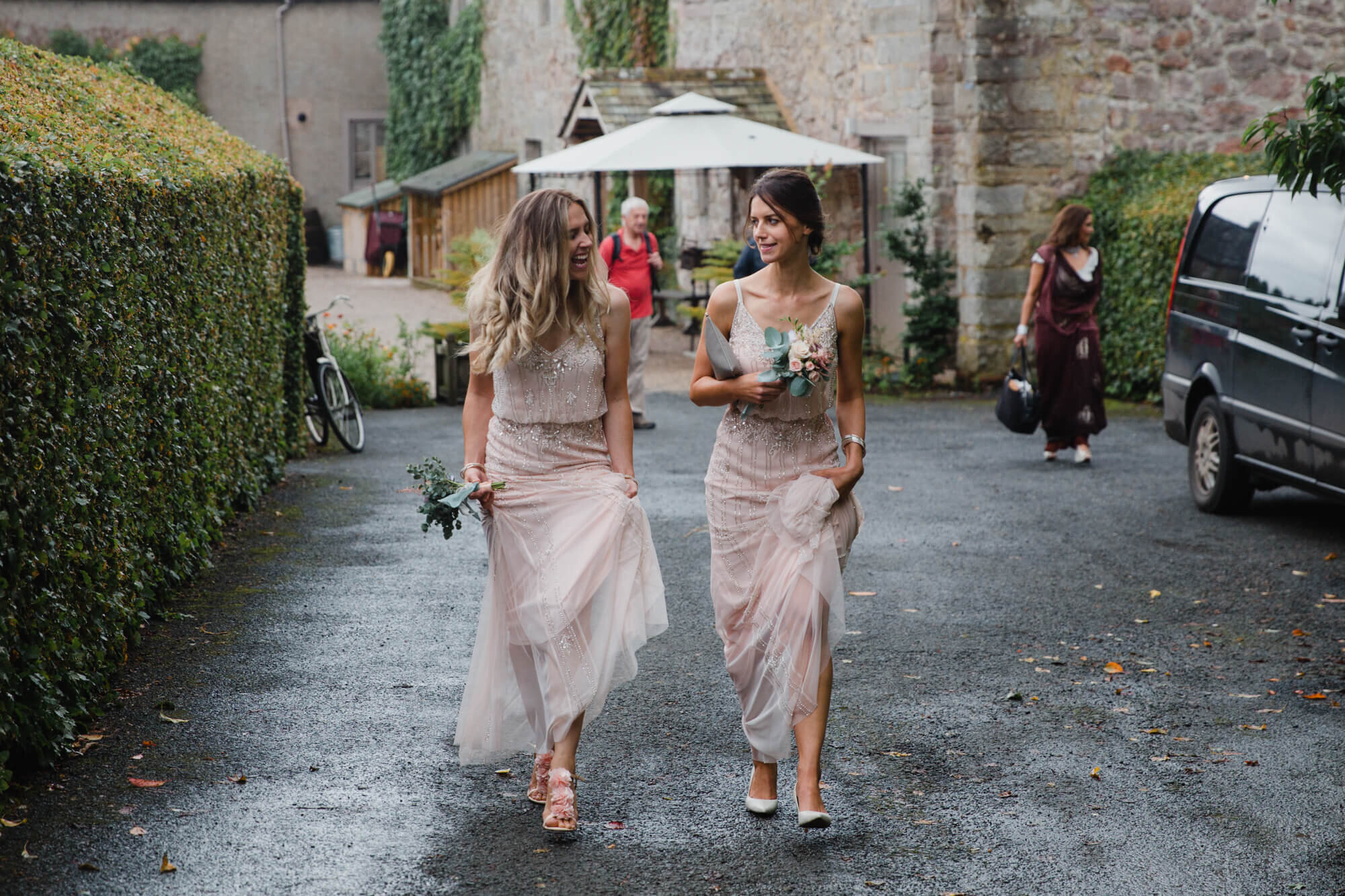 bridesmaids sample cumbria weather while walking to ceremony