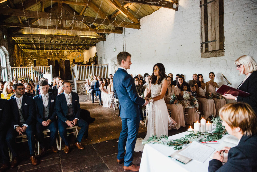 wide angle photograph taken from gallery as newlyweds exchange nuptials