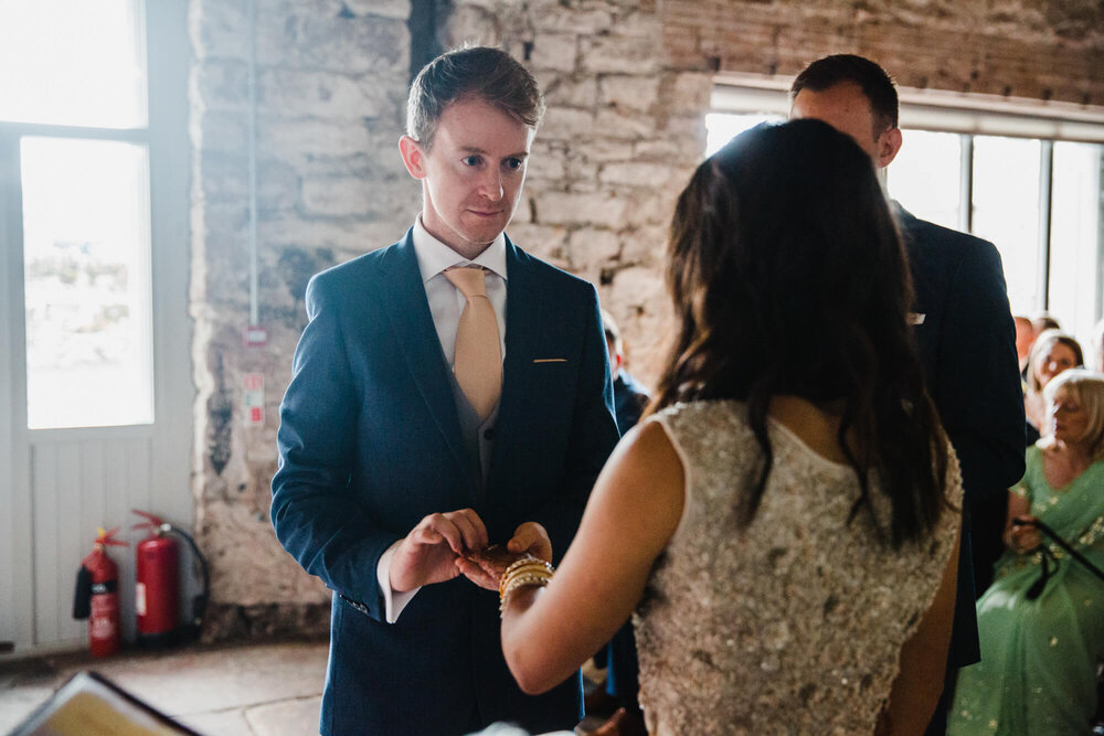 groom exchanges wedding ring with bride