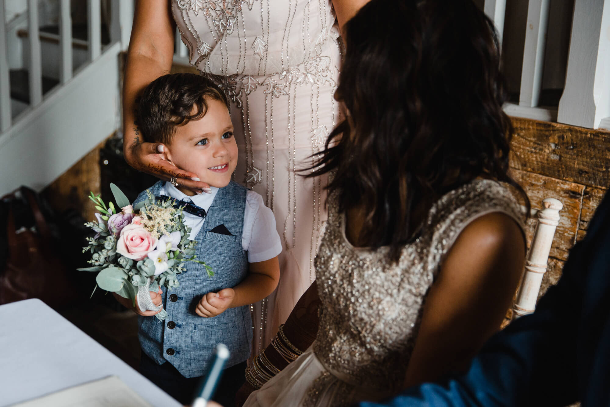page boy holding bouquet while sharing moment with bride