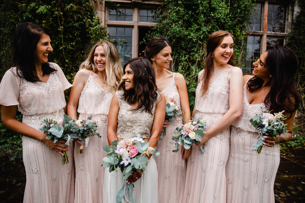 bridesmaids hold bouquets while posing to camera