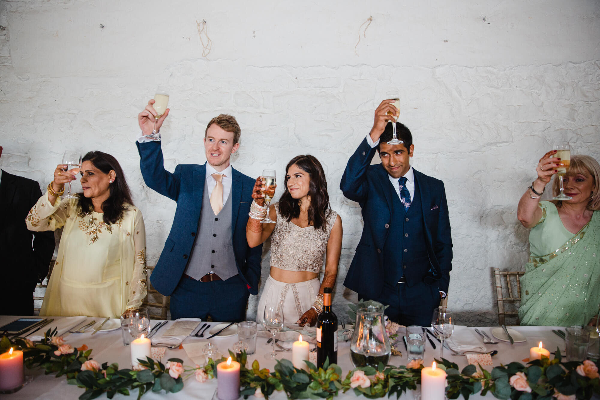 wedding party raise toast with drinks glasses at end of speech