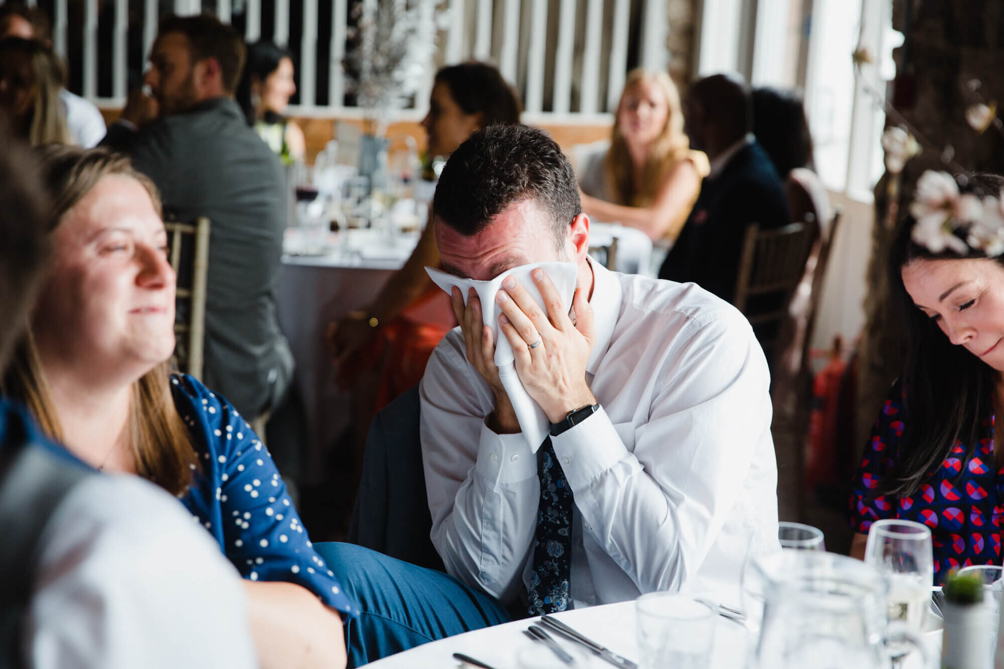 guest laughing into napkin during speeches