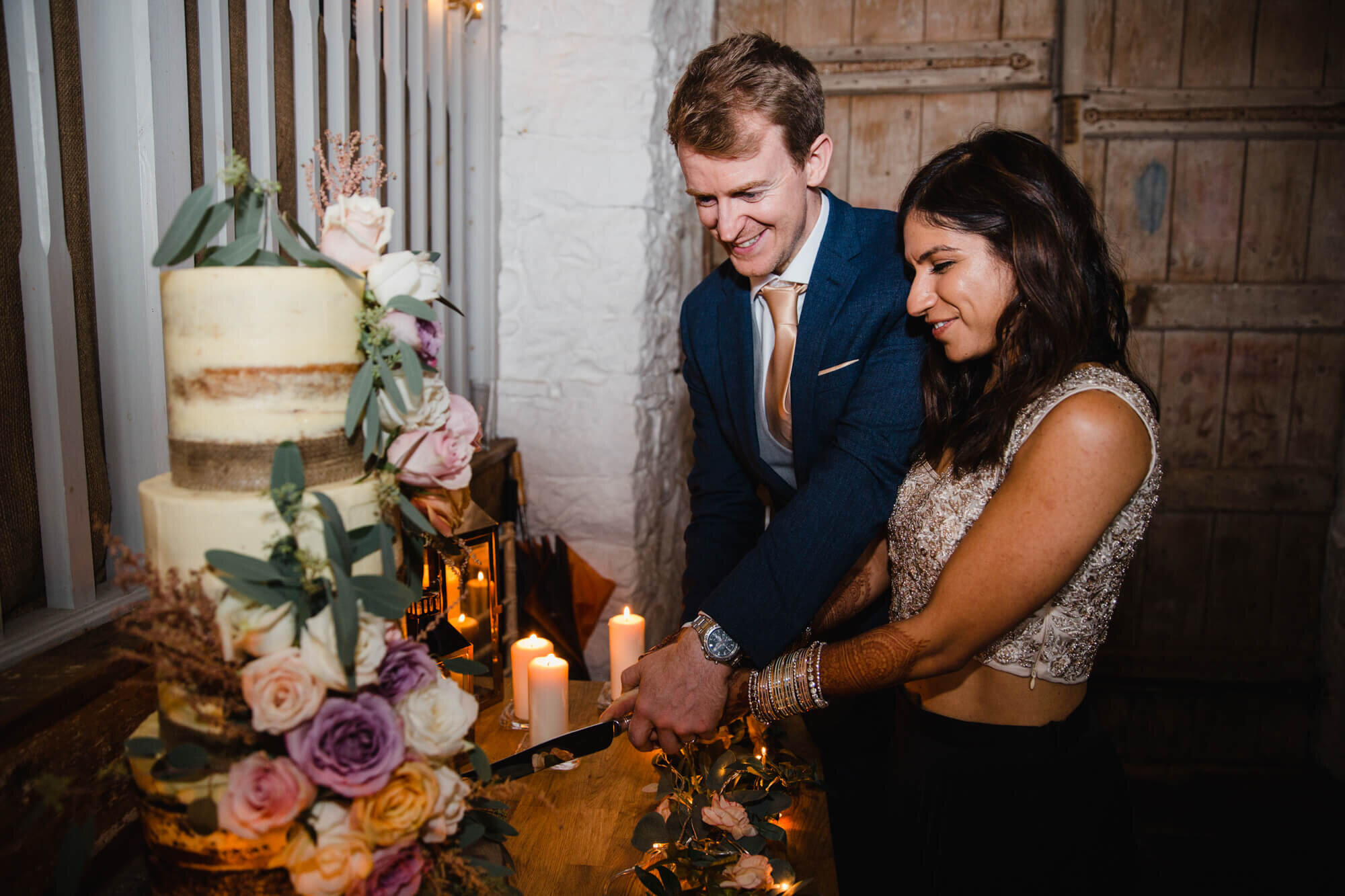 wedded couple cut award winning cake together at Askham Hall