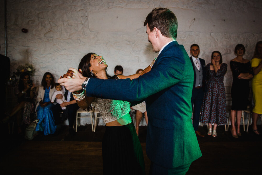 first dance as newlyweds are surrounded by wedding party group