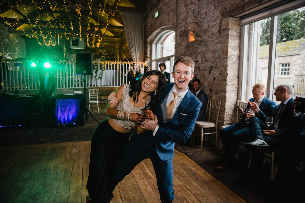 newly married couple pose to camera after their dance