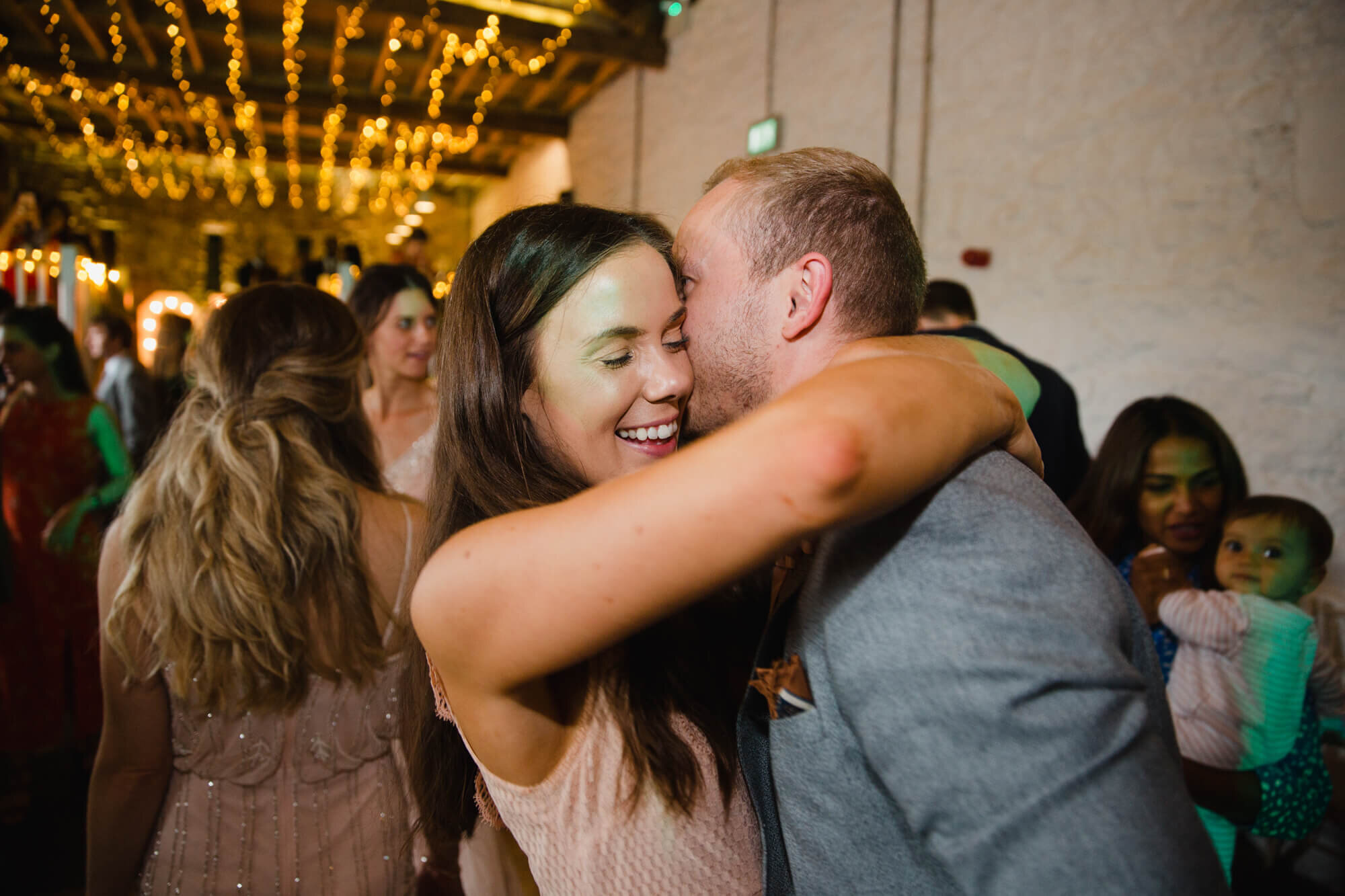 bridesmaid hugs partner on dancefloor