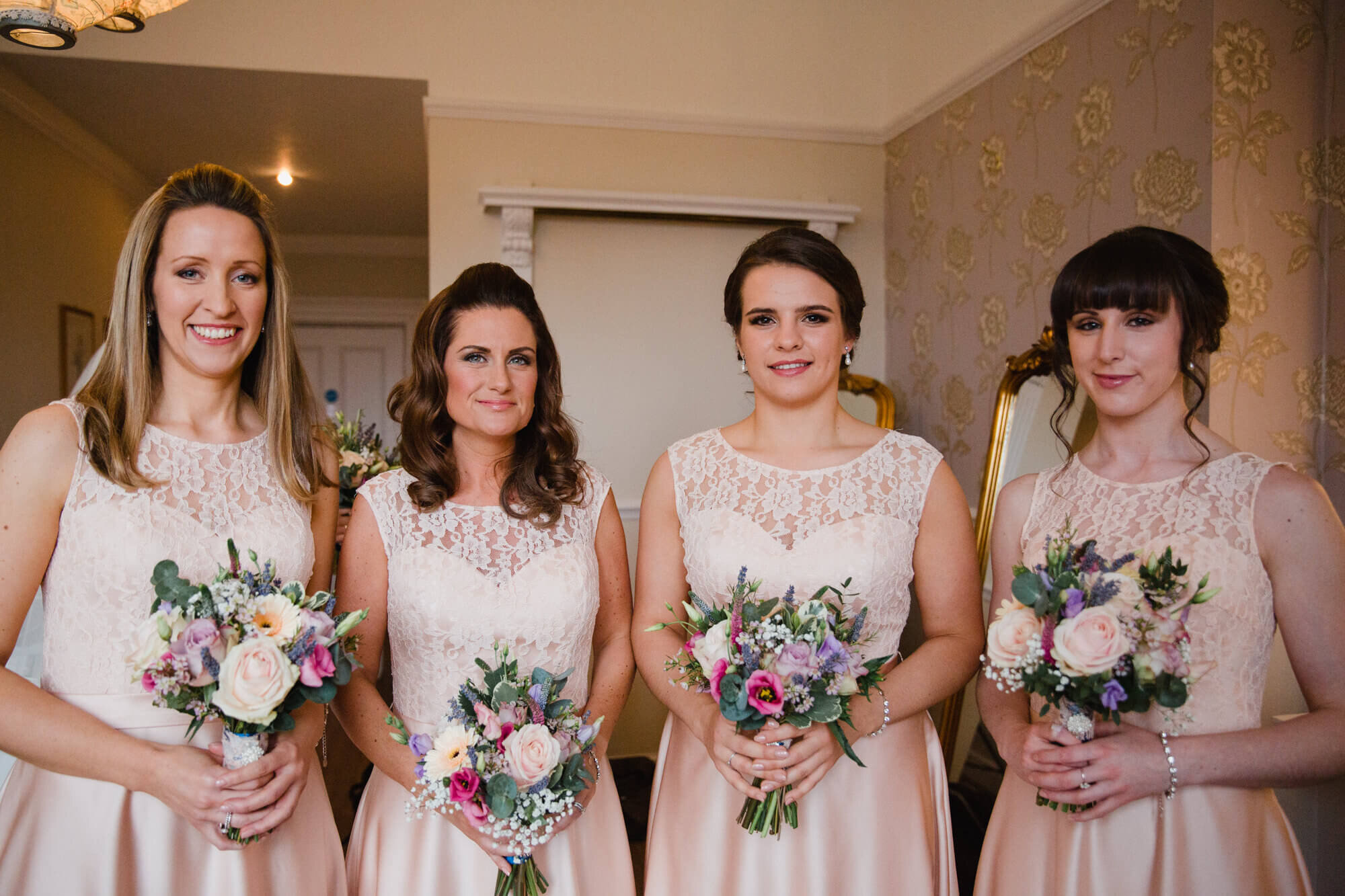 bridesmaids holding bouquets in bridal suite of Ashfield house