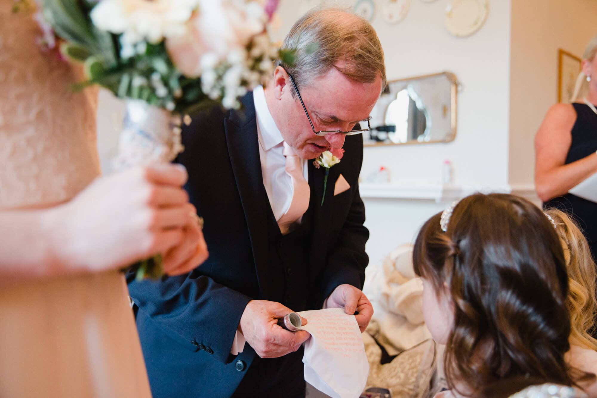 father of bride sharing moment with flower girls