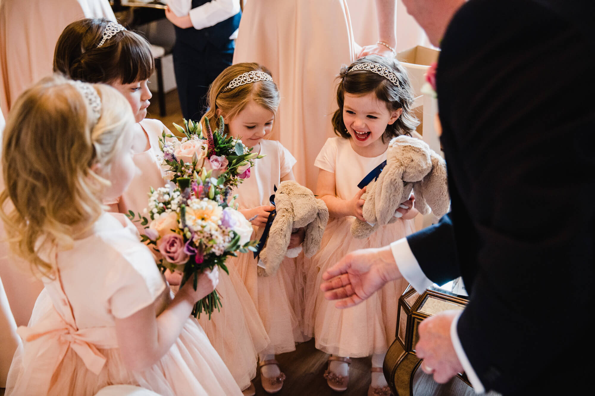 flower girls holding rabbit toys and laughing in bridal suite