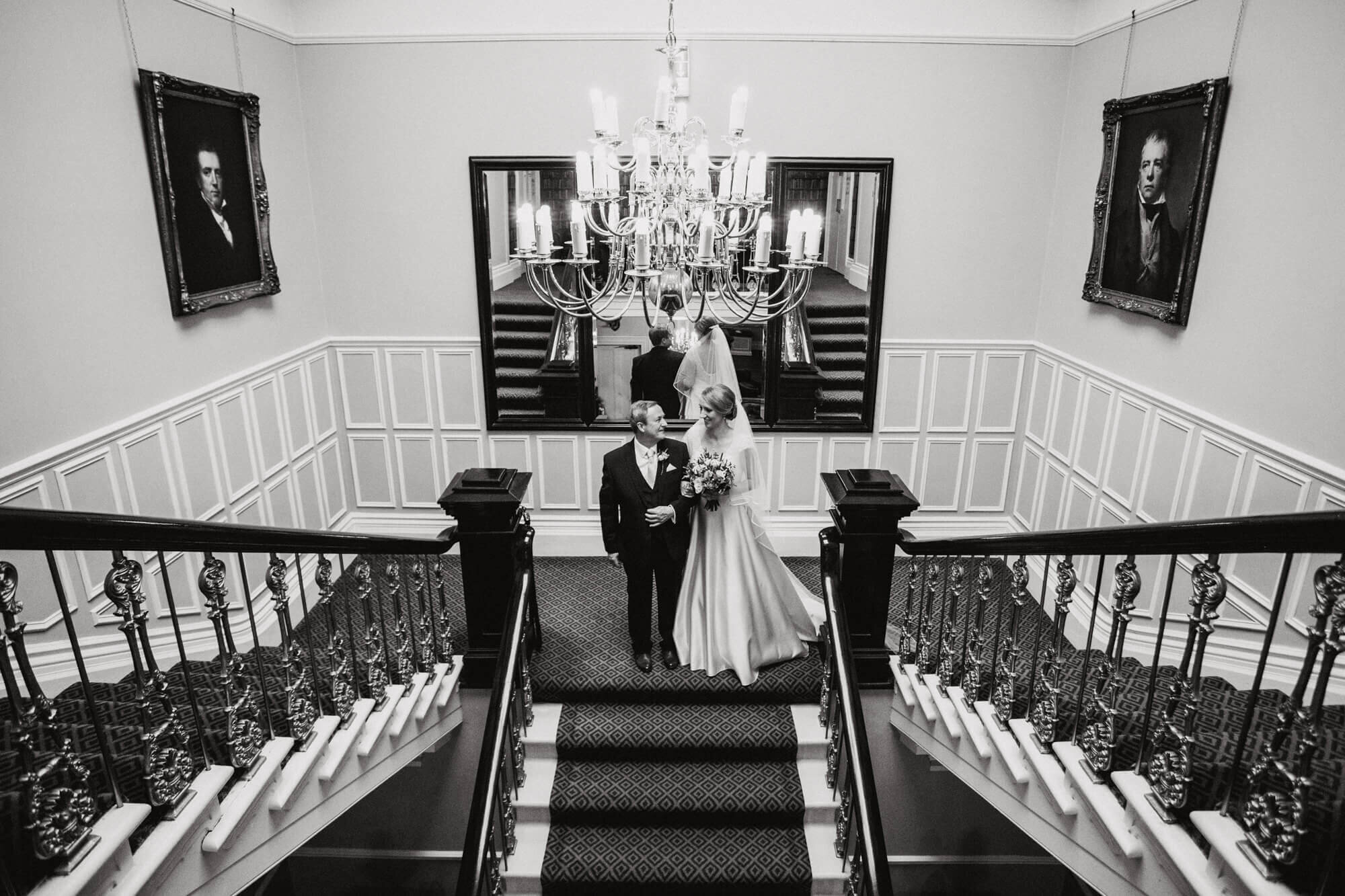 wide angle lens photograph of bride and father on staircase