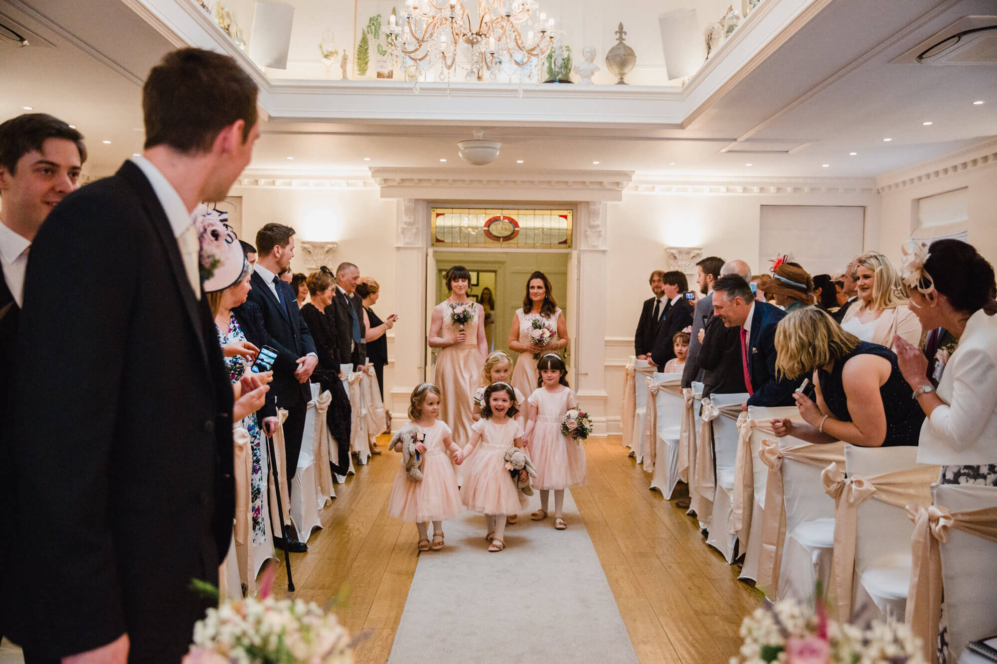 flower girls walking down aisle holding bouquets during entrance processional