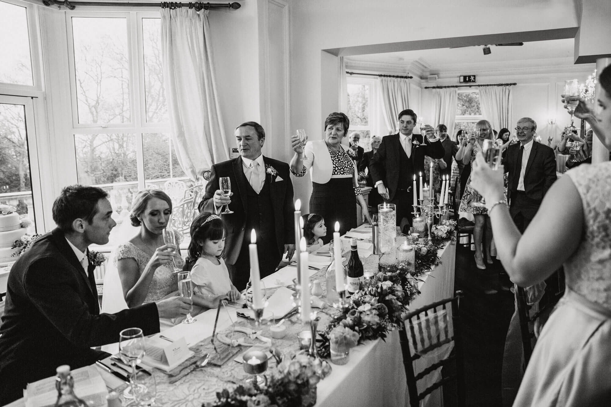 wedding guests raise toast to newlyweds at end of speeches