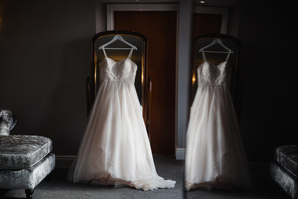 low light exposure photograph of wedding dress in reflection of window