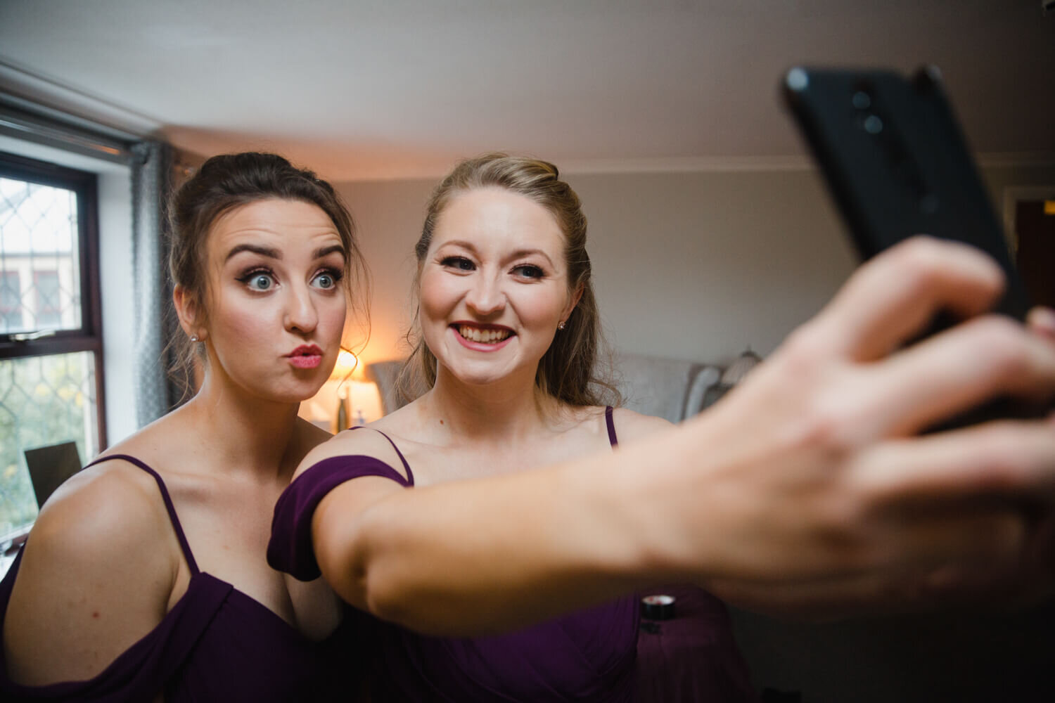 bridesmaids taking selfie photograph on camera phone