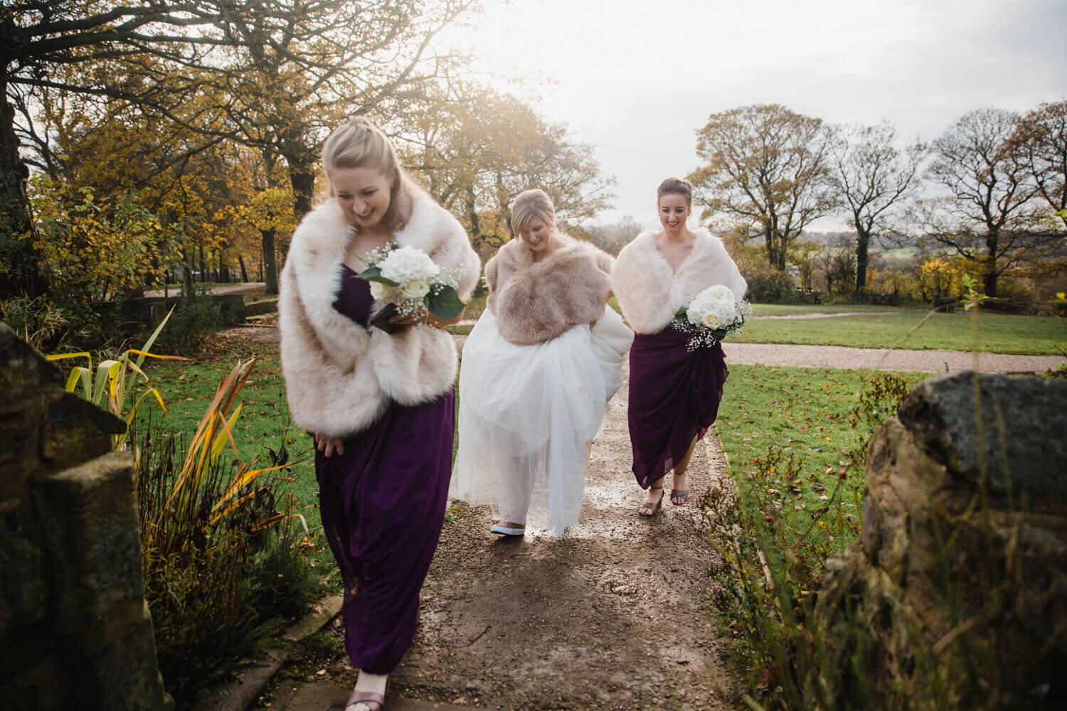 bride walking into Oakwell Hall with bridesmaids holding bouquets