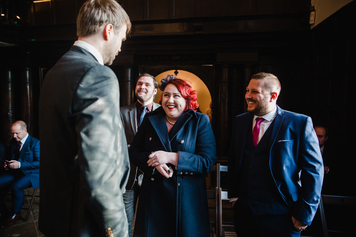wedding guests sharing joke with groom before ceremony processional
