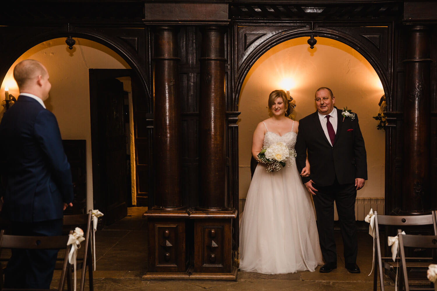 bride and father enter ceremony room together for service to commence