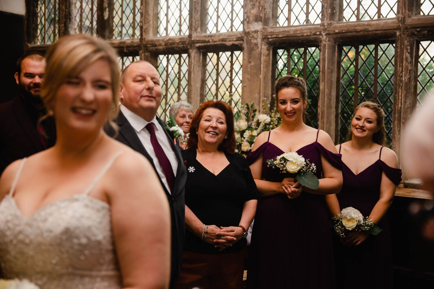 bridal party share joke as bride laughs in foreground of photograph
