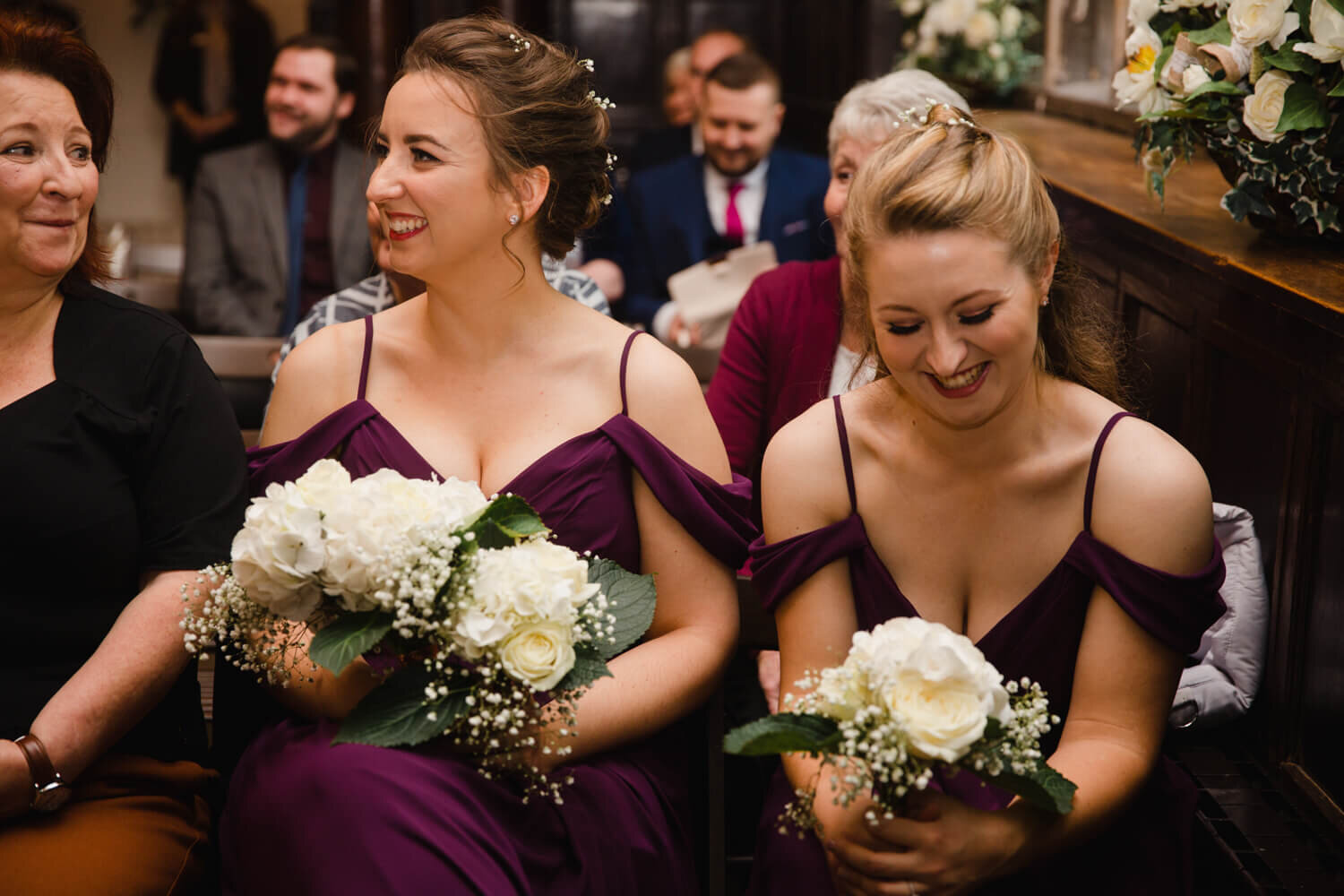 bridesmaids holding bouquets and sharing joke