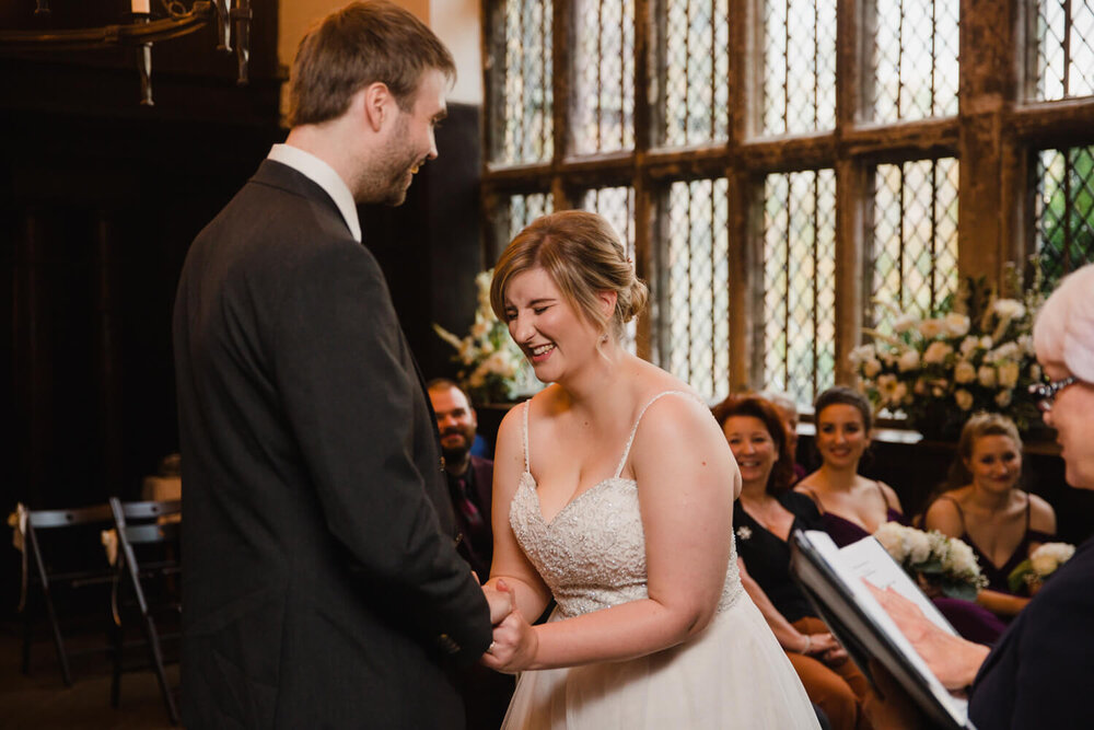 bride and groom laughing together while holding hands