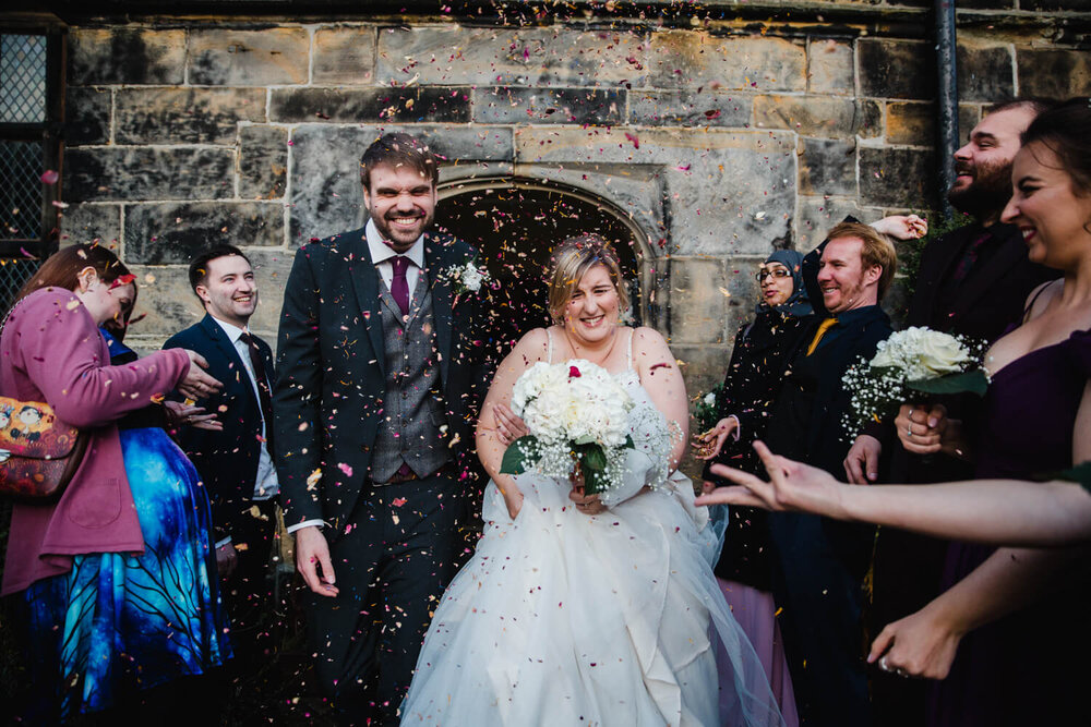 happily married couple enjoying the confetti being thrown by guests