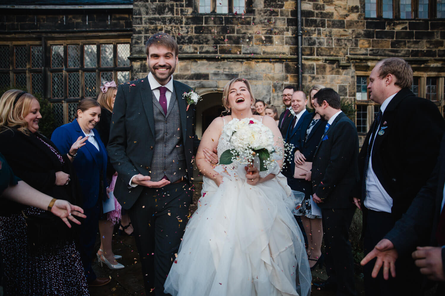 newlyweds laughing at confetti throw