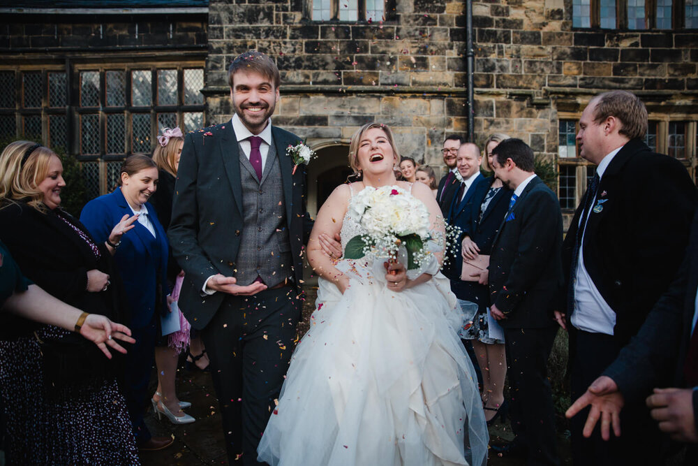 newlyweds laughing at confetti throw