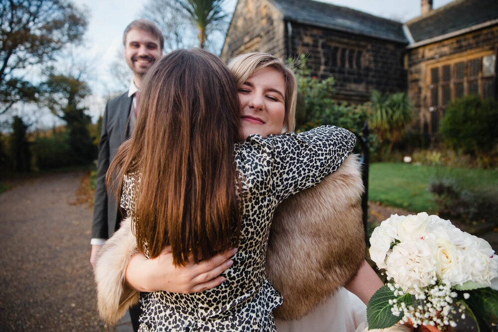 wedding guests share hugs with bride after confetti throwing