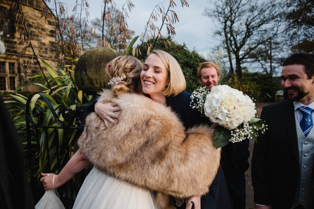 wedding guests hug after service finishes