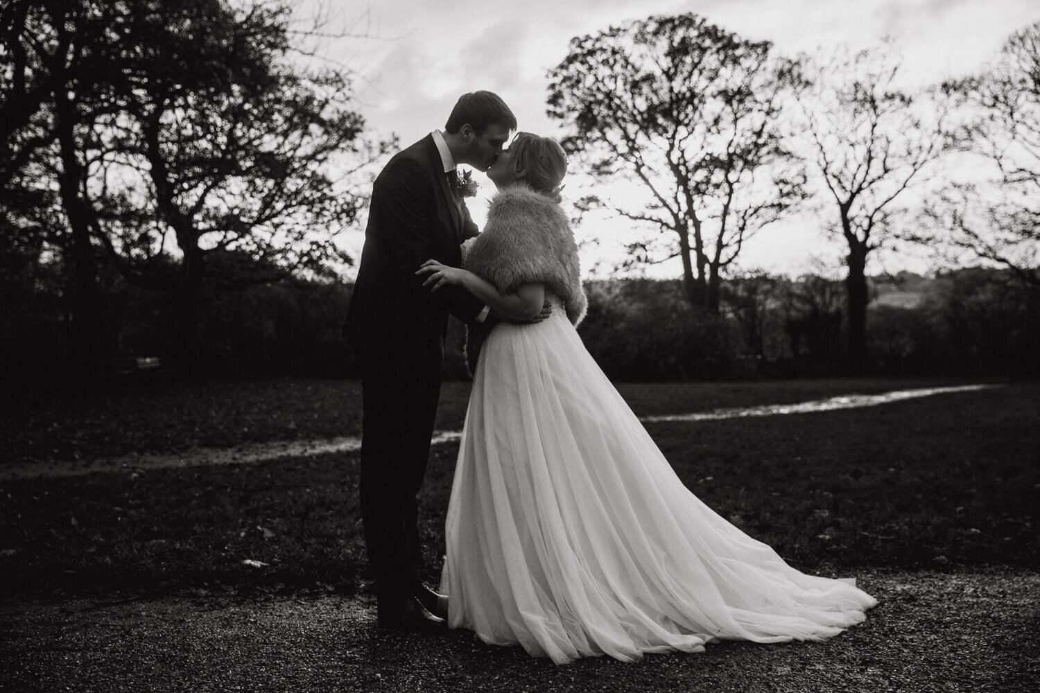 black and white monochrome photograph of newly married couple kissing