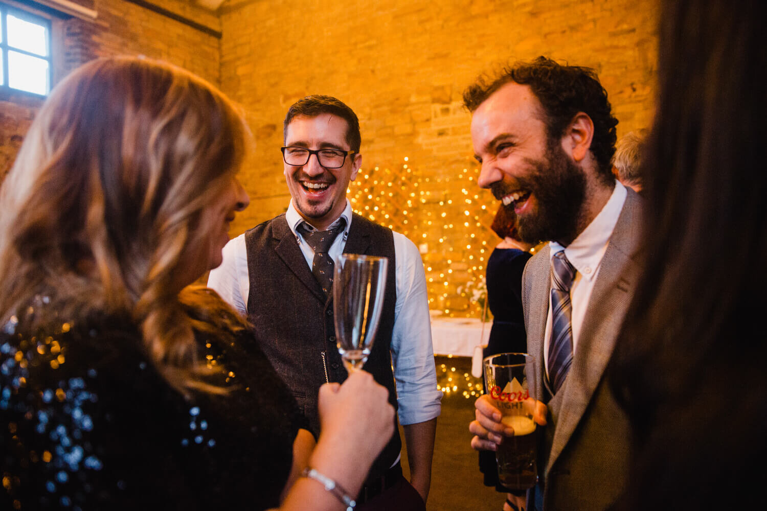 wedding guests share jokes together during cocktail hour