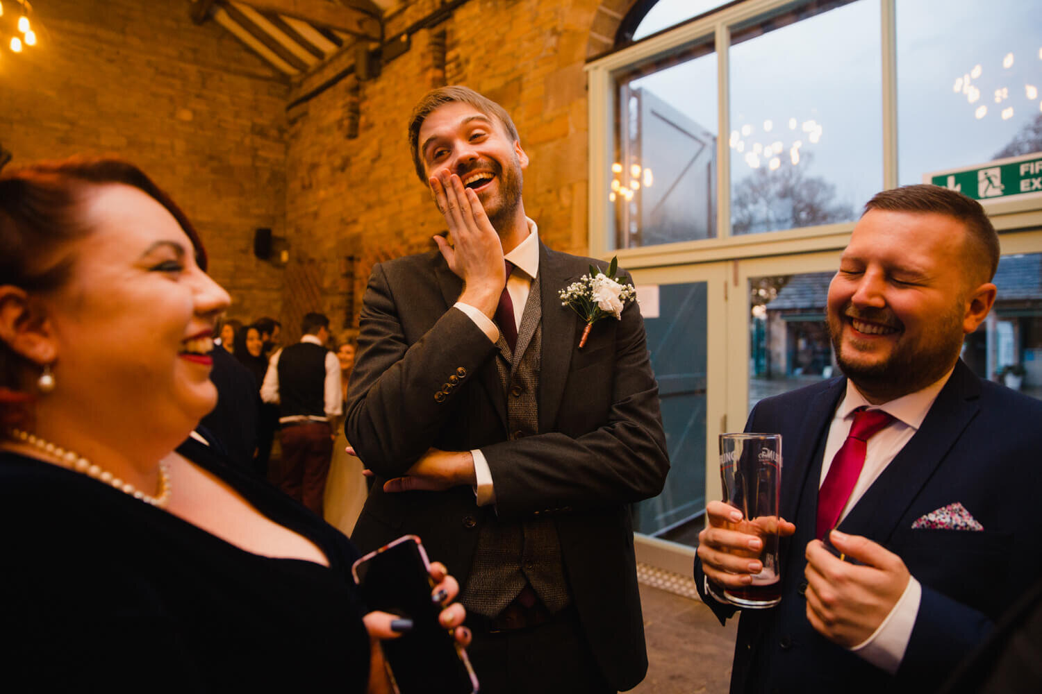 groom shares a joke with friends