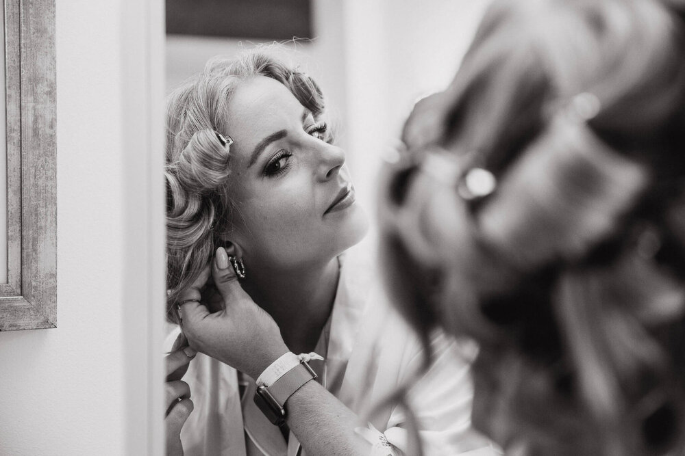 black and white photograph of bridesmaid getting ready in bridal suite