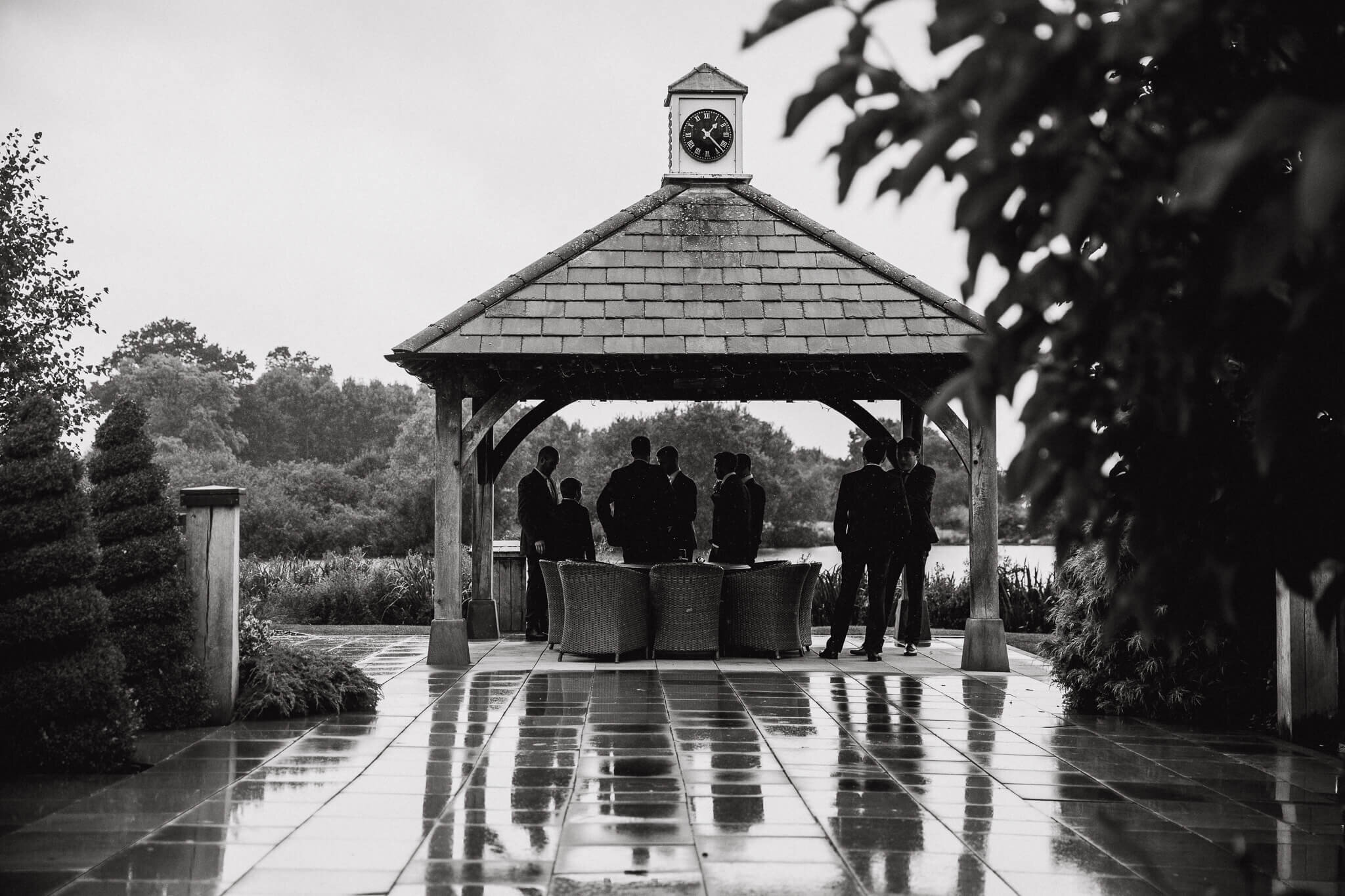 black and white reflection photograph of groomsmen before ceremony