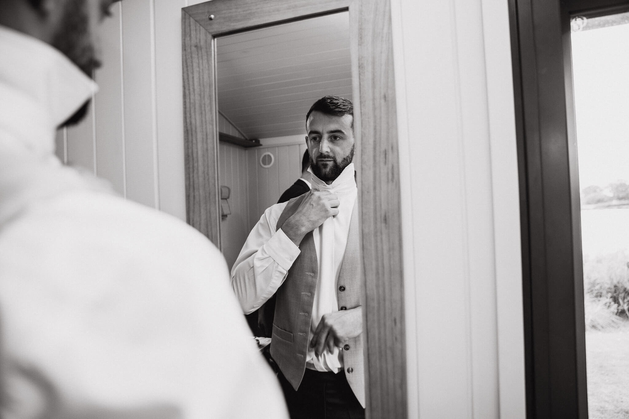 Mark looking slightly nervous while fastening tie