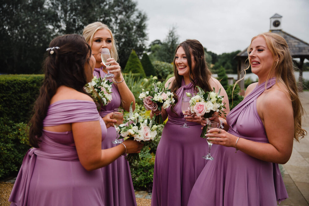 bridesmaids holding bouquets outside entrance