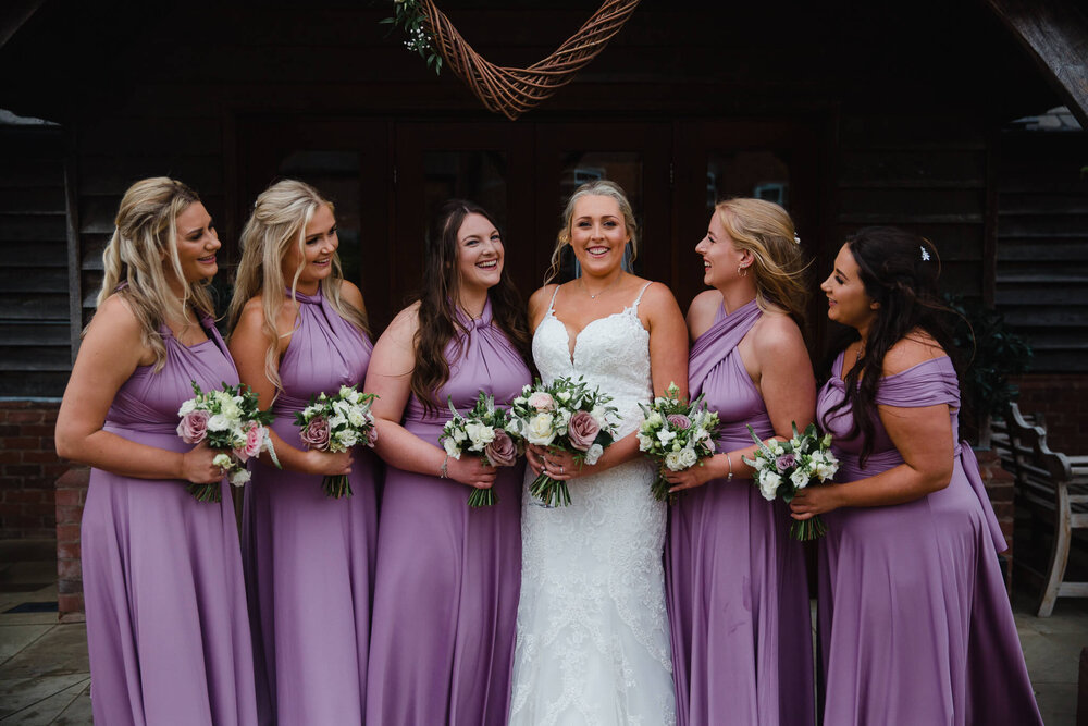 bridesmaids together outside venue holding bouquets