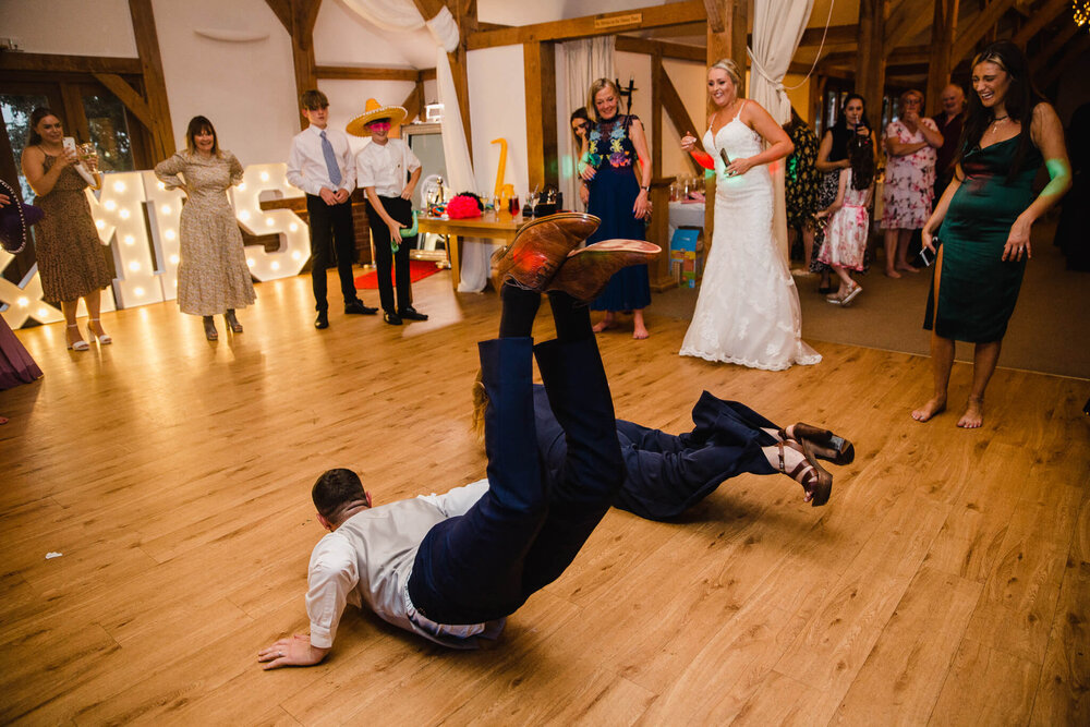groom performs worm dance on wooden floor