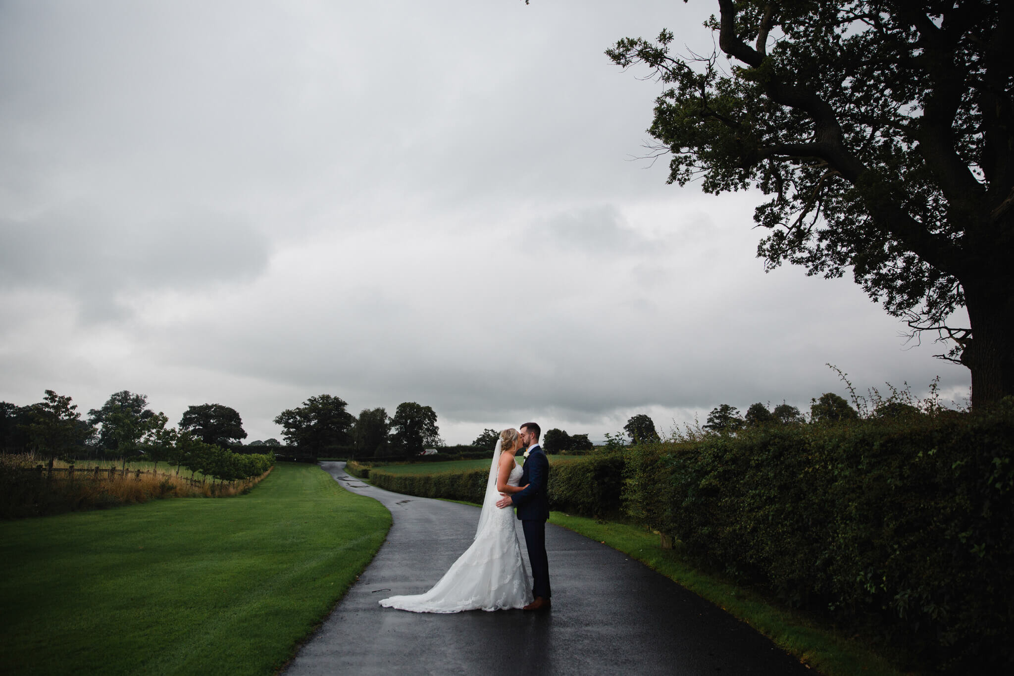 wide angle lens photograph of newlyweds on road location