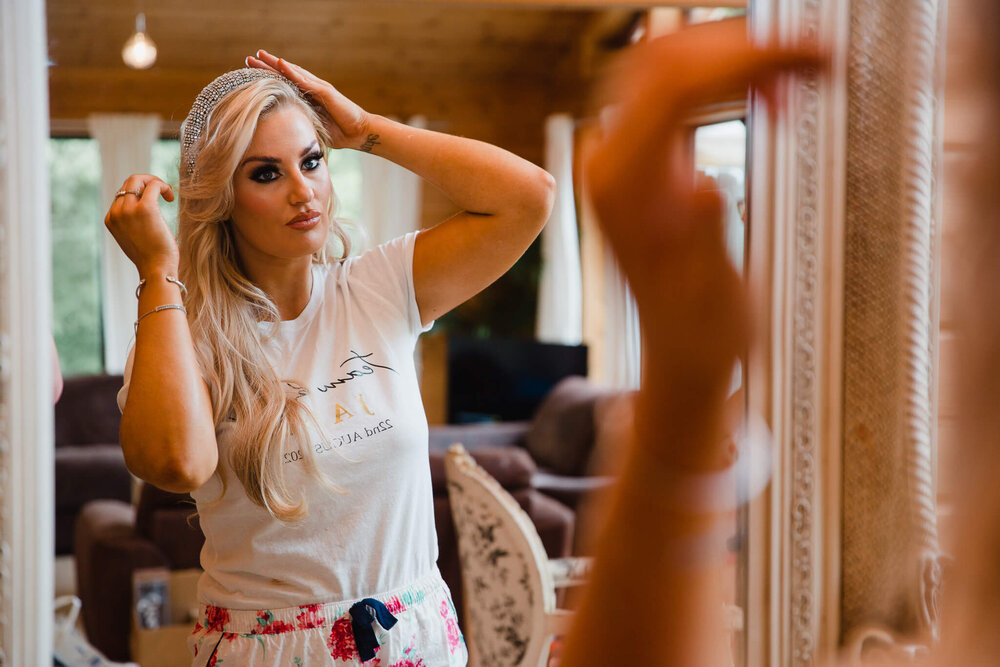 bridesmaid preparing hair in mirror