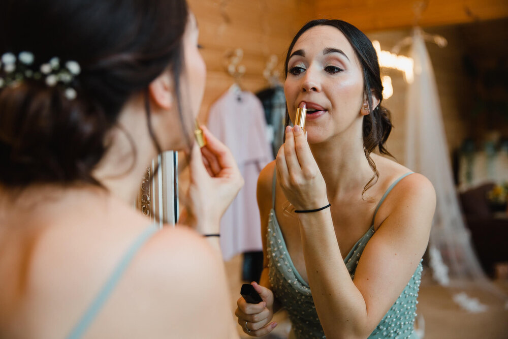 close up of bridesmaid applying lipstick