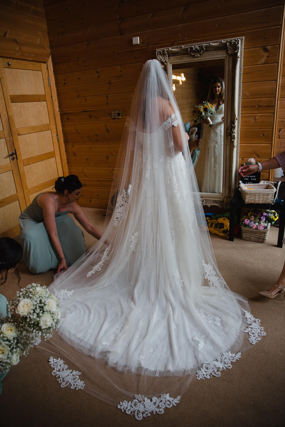 wide angle photograph of wedding dress and flowers