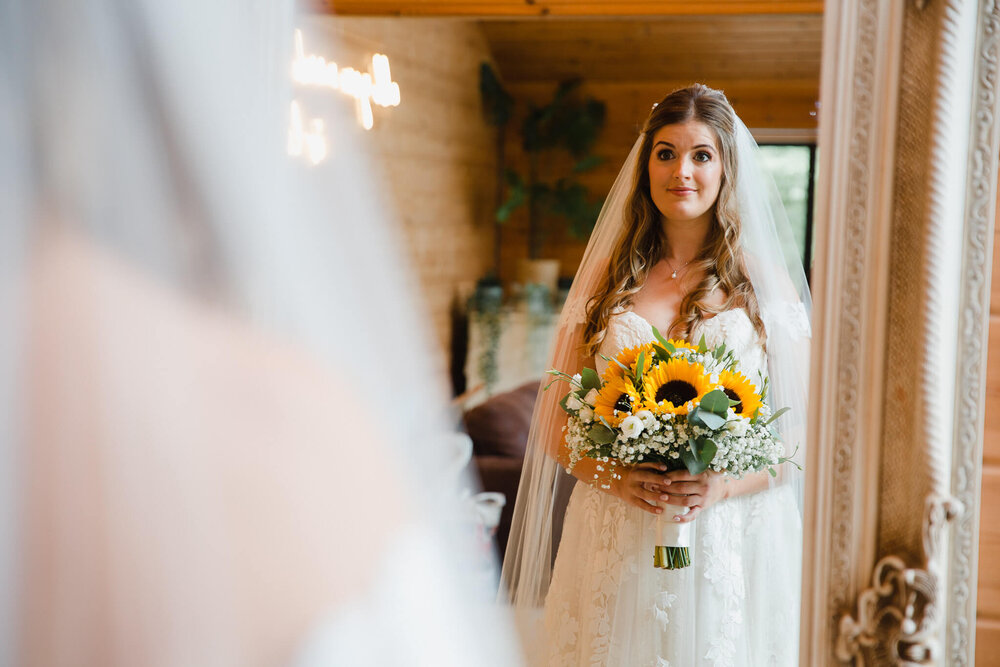 bride holding bouquet in mirror