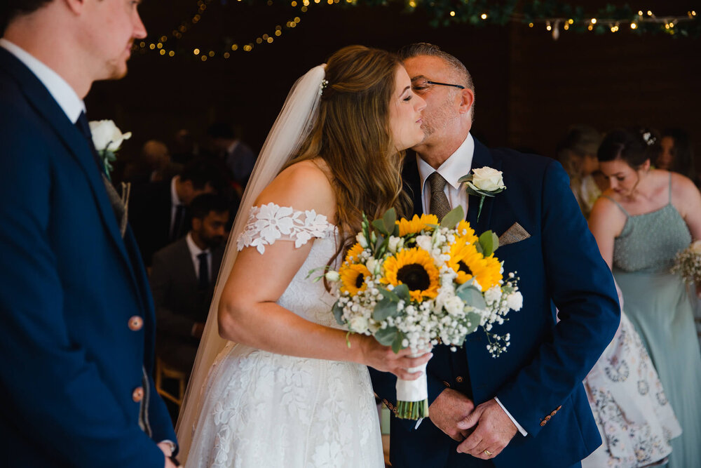 father of bride sharing kiss before ceremony begins