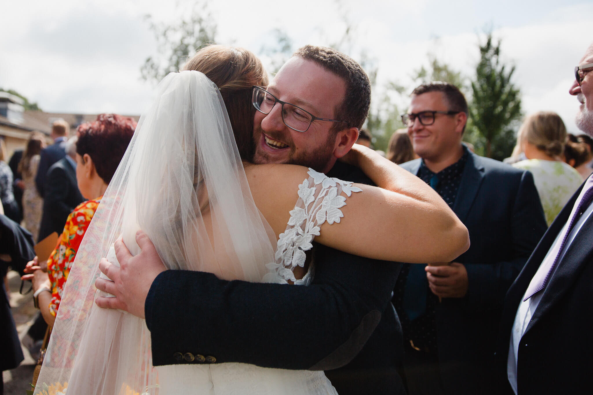 bride hugging guests and being congratulated