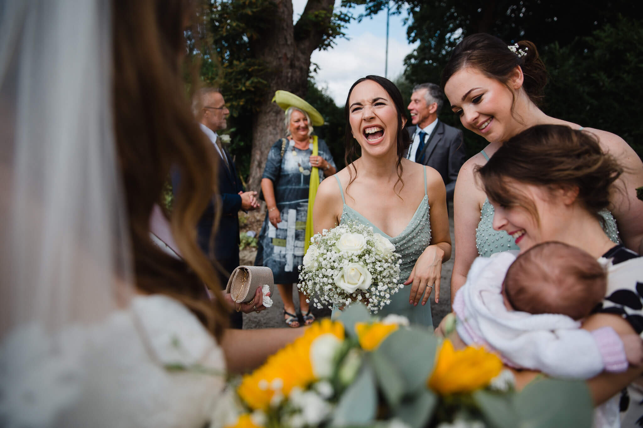 bridesmaid shares joke with bride outside