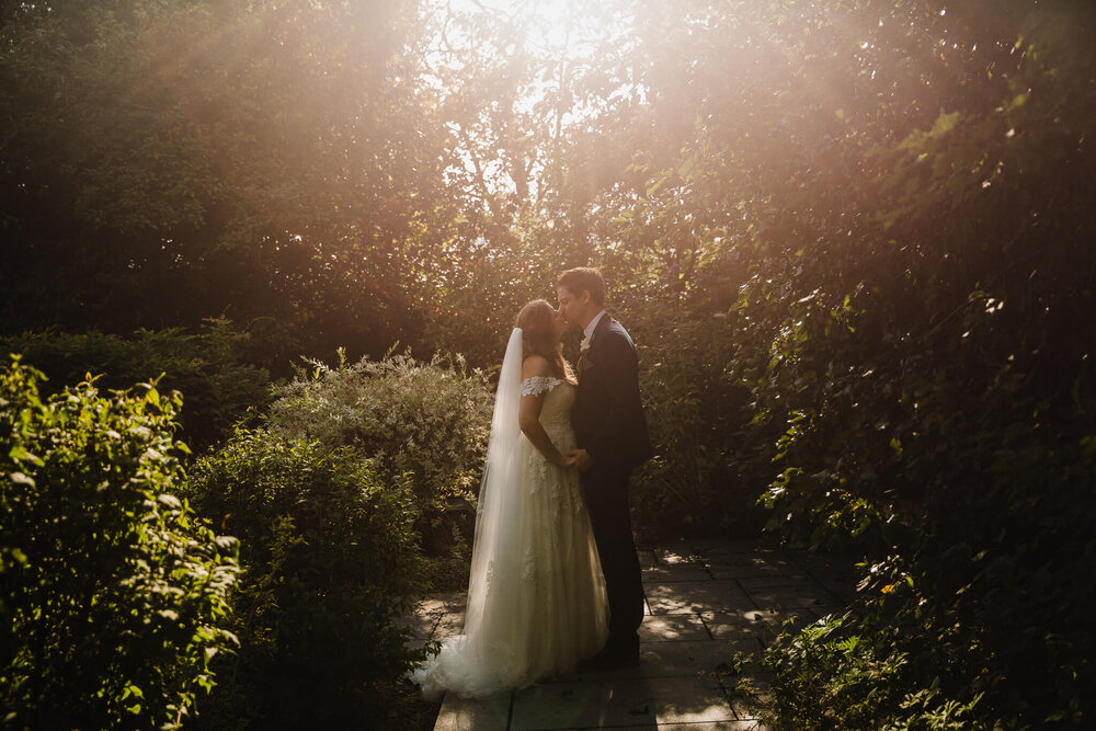 wide angle sunset kiss of bride and groom together