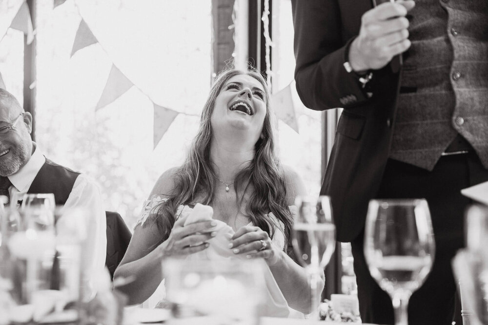 black and white photograph of bride laughing