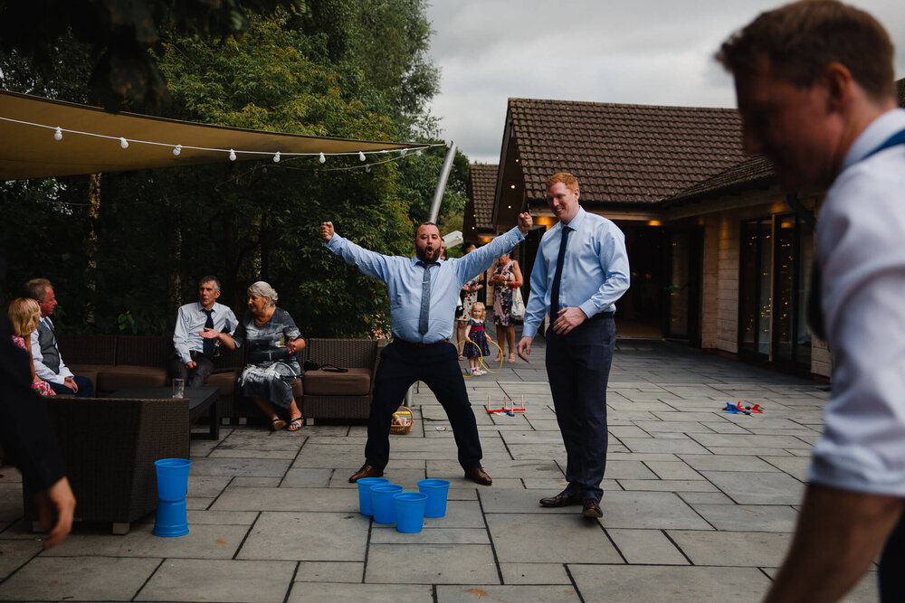 wedding guest celebrates winning beer pong